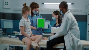 Tablet üzerinde yeşil ekran kullanan asistanın üç ayaklı görüntüsü