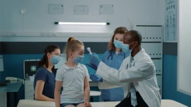 Doktor termometreyle koronavirüs belirtilerini kontrol ediyor.