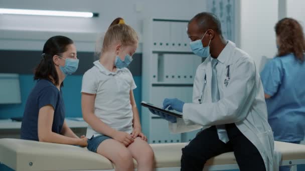 Pediatra stosujący tabletkę do sporządzania notatek podczas konsultacji — Wideo stockowe