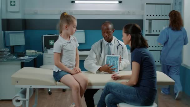 Sanitäter und Eltern überprüfen Röntgenbilder von Kindern, um eine Diagnose zu finden — Stockvideo
