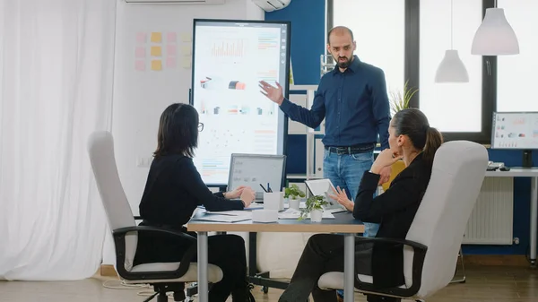 Hombre apuntando a la televisión con presentación gráfica — Foto de Stock