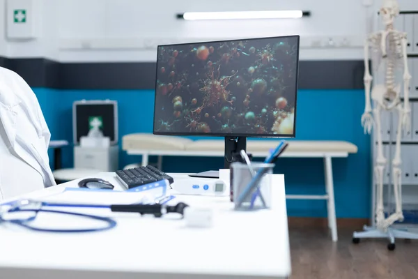 코로나 바이러스 세포가 들어 있는 컴퓨터를 들고 있는 텅 빈 병원 사무실 — 스톡 사진