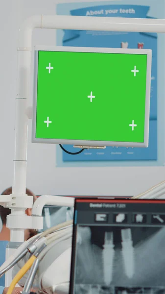 Женщина работает стоматологом с зеленым экраном и рентгеновским сканированием — стоковое фото