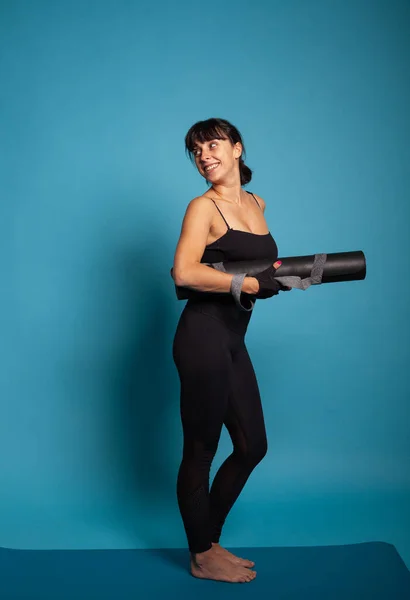 Tappetino da yoga per donna attiva atletica dopo aver terminato l'allenamento di fitness — Foto Stock