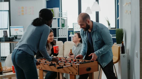 サッカーテーブルでゲームを楽しむ多様な労働者のグループ — ストック写真