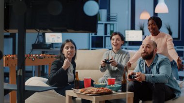 Neşeli insanlar joysticklerle video oyunları kazanıyor.
