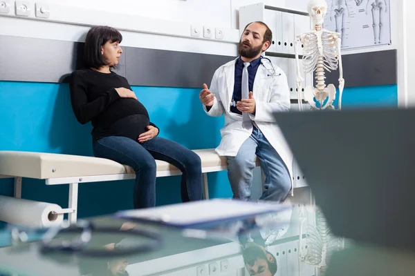 Annelik uzmanı ofisteki hamile yetişkinlere tavsiye veriyor. — Stok fotoğraf