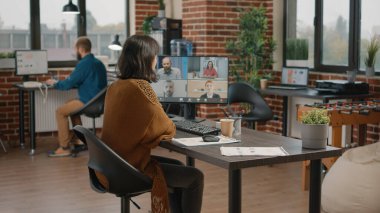 Çalışan iş arkadaşlarıyla konuşmak için bilgisayardaki video çağrısını kullanıyor