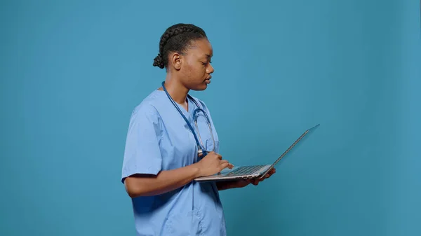 Портрет женщины-медсестры, работающей на современном ноутбуке — стоковое фото