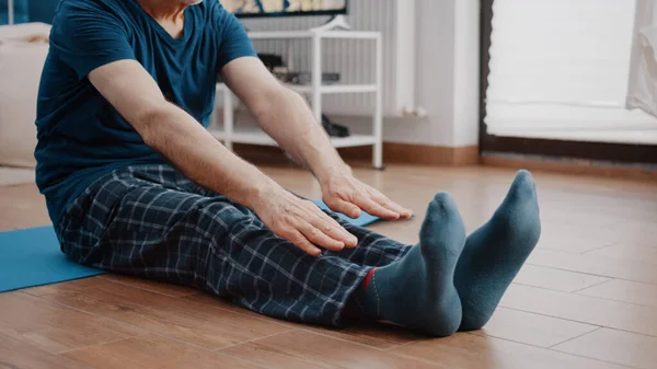 Close-up van de oude man doet stretch oefening op yoga mat — Stockfoto