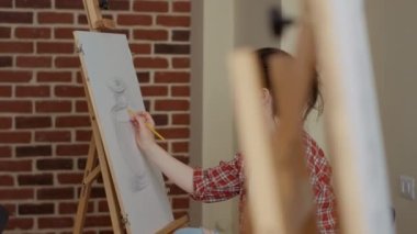 Beyaz tuvale yaratıcı tasarım çizen genç bir kadının portresi