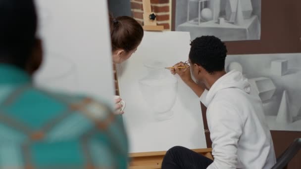 Młody nauczyciel rozmawia z uczniem o rysunku — Wideo stockowe