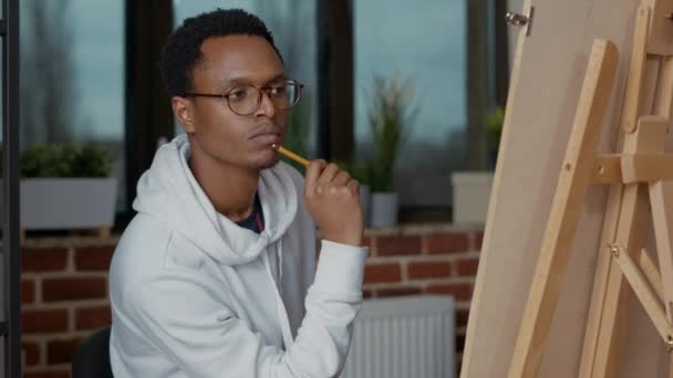 Młody student tworzący nowoczesną sztukę na płótnie ołówkiem — Wideo stockowe