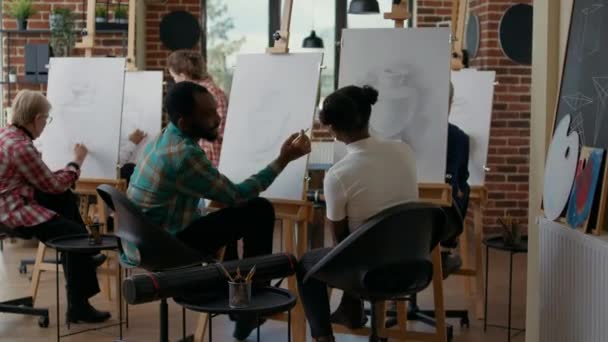 Afrikai amerikai férfi és nő csevegnek és rajzolnak vászonra — Stock videók