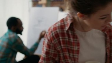 Öğretmen genç kadına vazo modelinin nasıl çizileceğini anlatıyor.