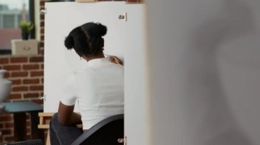 Resim yapmak için kalem ve tuval kullanan kız öğrenci