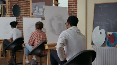 Resim dersinde Afrikalı Amerikalı öğrenci vazo çiziyor.