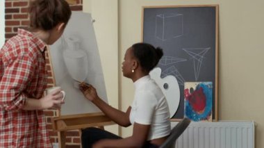 Resim kursuna katılan genç bir kadın çizim becerisi öğreniyor.