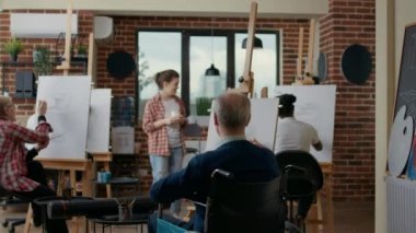 Tekerlekli sandalyedeki son sınıf öğrencisi sanat dersine gidiyor.