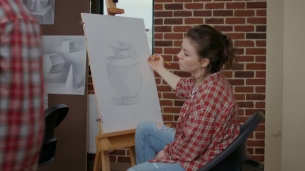 Jonge vrouw met potlood om meesterwerk op doek te tekenen — Stockvideo