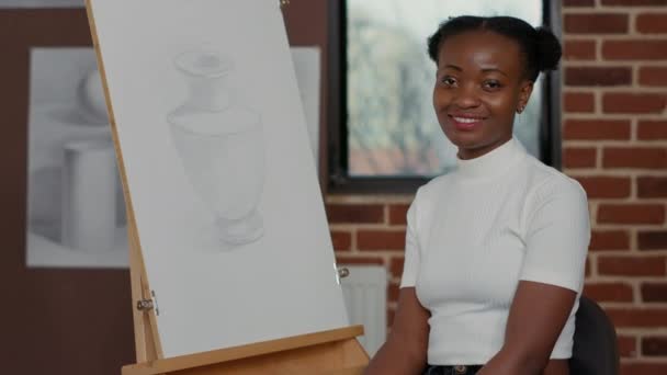 Retrato de mujer creativa sentada frente al lienzo con dibujo — Vídeo de stock