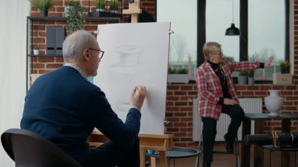 Resim dersinde, yaşlı öğrenci tuvale vazo resmi çiziyor. — Stok video