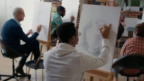 Afrikai amerikai diák ceruzával rajzolni váza modell vászonra — Stock videók