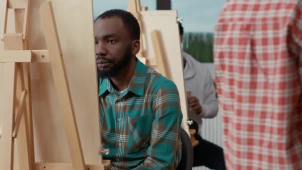 Estudiante afroamericano impresionado por obras de arte sobre lienzo — Vídeos de Stock