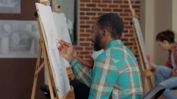 Πορτρέτο του νεαρού άνδρα αντλώντας έμπνευση αντικείμενο στην τάξη τέχνης — Αρχείο Βίντεο