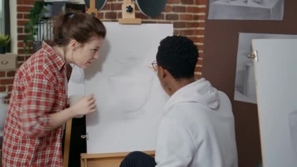 Jonge vrouw legt artistieke les uit aan student in de kunstklas — Stockvideo