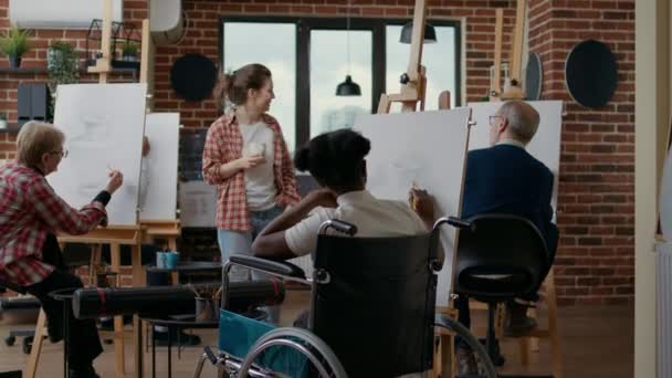 Jonge vrouw met een handicap leren tekenen schets op doek — Stockvideo