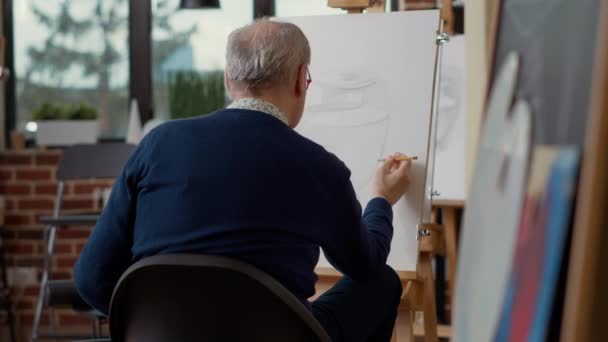 Seniorchef skizziert mit Bleistift Inspirationsmodell in Kreativwerkstatt — Stockvideo