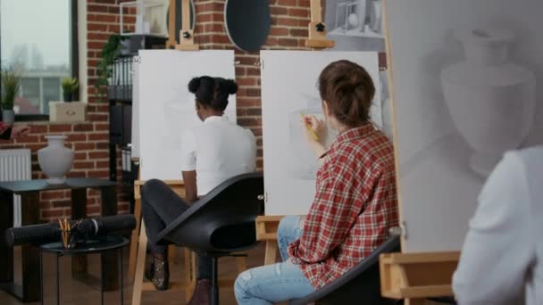 Jonge vrouw met potlood om vaas op wit doek te tekenen — Stockvideo