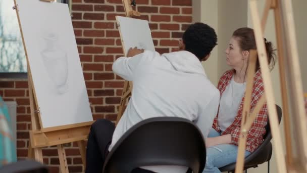 Vielfältiges Studententeam zeichnet Inspirationsmodell auf Leinwand — Stockvideo