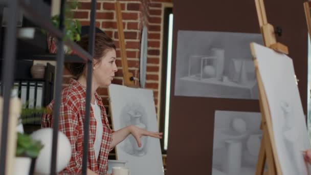 Γυναίκα καλλιτέχνης χρησιμοποιώντας το μοντέλο βάζο για να εξηγήσει την τεχνική σχεδίασης — Αρχείο Βίντεο