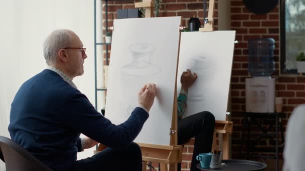 Oude student met potlood om vaasmodel te schetsen in creatieve werkplaats — Stockvideo