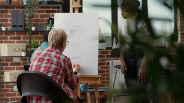 미술 학교 의연로 한 학생에게 그림을 가르치는 젊은 미술가 — 비디오
