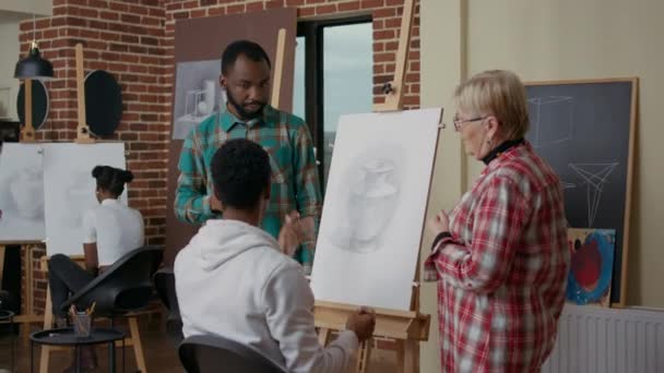 Old teacher and student helping african american man to draw vase — Stock Video