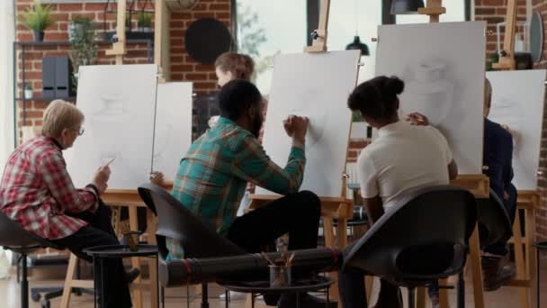 Jóvenes estudiantes dibujando sobre lienzo y hablando sobre obras de arte — Vídeos de Stock