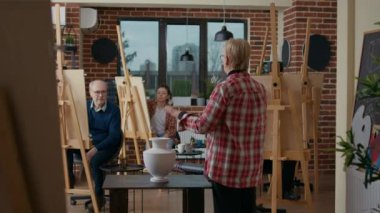 Sanat dersine katılan çok ırklı bir grup insan.