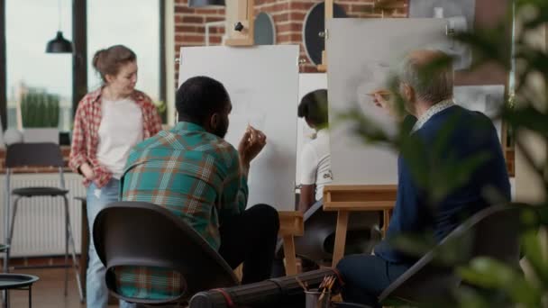 Team av ung man och äldre person som går på konstskola — Stockvideo