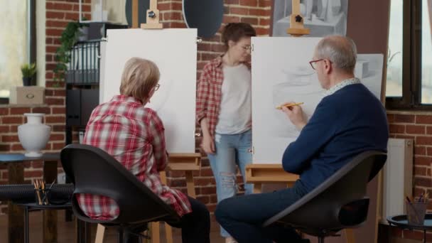 Ältere Menschen lernen in Kunstwerkstatt, auf Leinwand zu zeichnen — Stockvideo