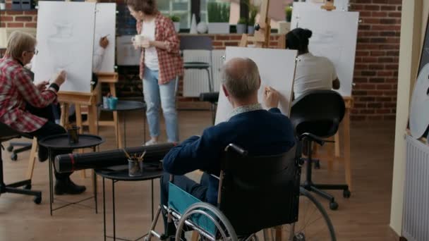 Oude man met een handicap met potlood om meesterwerk te tekenen — Stockvideo