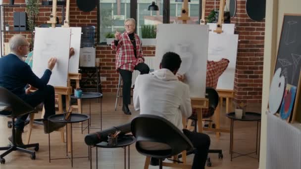 Äldre lärare talar om att teckna färdigheter på konstlektionen — Stockvideo