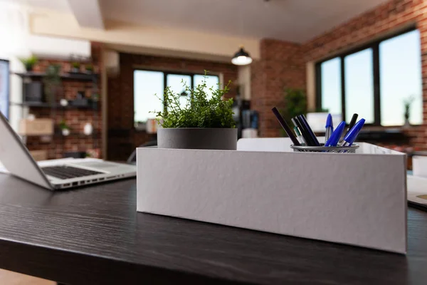 Sluiten van kantoordecoraties in doos en laptop op bureau — Stockfoto