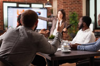 Yönetici yöneticisi proje fikirlerini tartışıyor ve monitöre işaret ediyor