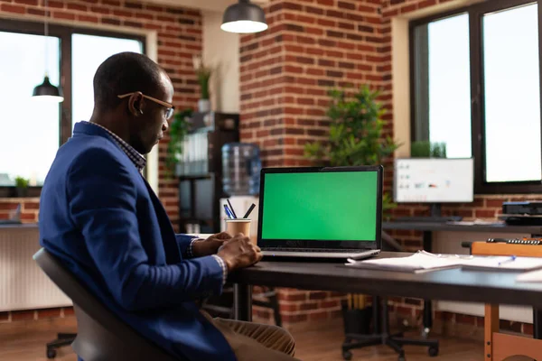 Imprenditore che utilizza laptop con schermo verde orizzontale per lavorare sul progetto aziendale — Foto Stock