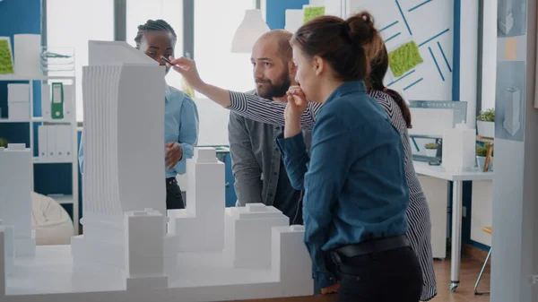 Multietniska personer som arbetar med byggnadsmodell för att utforma stadsbyggnadsprojekt — Stockfoto
