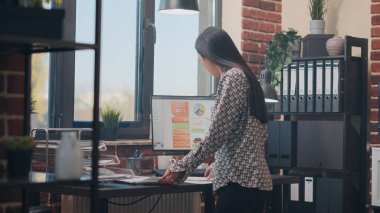 İş projesini planlamak için evrakları analiz eden Asyalı kadın.