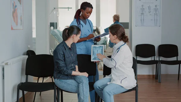 Team of nurse and doctor showing radiography on tablet — ストック写真